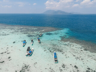 Fototapeta na wymiar Top view or aerial view of beautiful clear water and white beach with long tail boats on summer tropical island called Karimunjawa in Jepara, Indonesia.