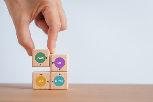 For continuous quality improvement model of four key stages (Plan, Do, Check, Action or PDCA), efficiency concept. Solving problems, improving organization  process. Hand completed wooden cube blocks