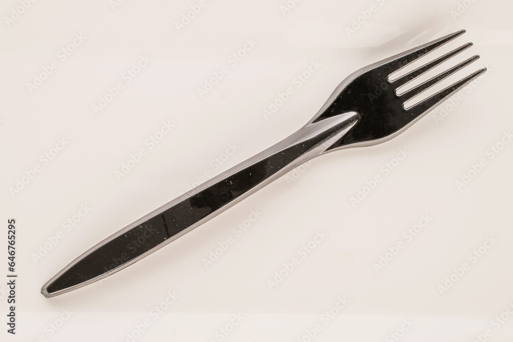 Wall mural One plastic fork on a white ceramic plate, macro, top view.