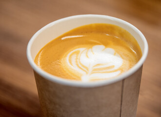 Coffee Cup on a brown rustic table. Bio paper cup with coffee.
