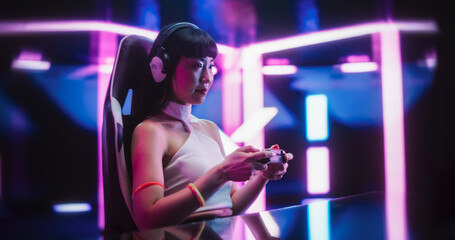 Japanese Female Playing Online Street Racing Simulator on a Computer. Footage of a Gamer Girl Sitting Behind a Table, Streaming Racing Gaming Content From a Futuristic Neon Room © Gorodenkoff