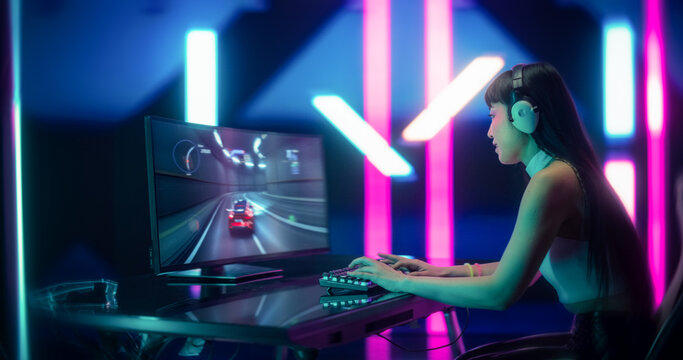 Young Japanese Female Gamer Playing Online Racing Game on Computer. Portrait of an Excited Woman in Headphones, Battling Diverse Players in a Web Motorsport Simulator