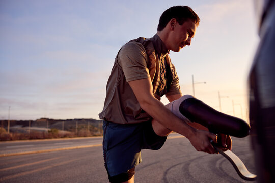 Young man preparing his prosthetic blade for an early run - Powered by Adobe