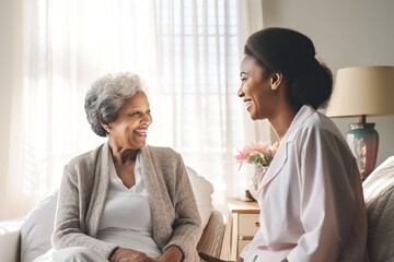 African american woman Doctor talking to a senior woman in bedroom modern white home - obrazy, fototapety, plakaty