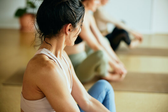Fit woman sitting on a yoga studio floor