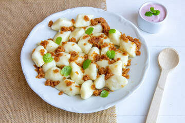 Lazy dumplings - a traditional Polish dish made of cottage cheese, potatoes, flour and eggs served with breadcrumbs fried in butter