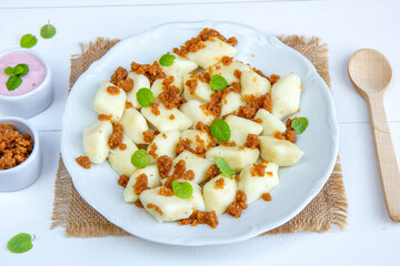 Lazy dumplings - a traditional Polish dish made of cottage cheese, potatoes, flour and eggs served with breadcrumbs fried in butter