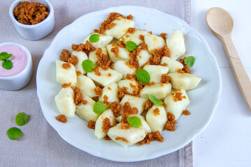 Lazy dumplings - a traditional Polish dish made of cottage cheese, potatoes, flour and eggs served with breadcrumbs fried in butter