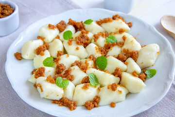 Lazy dumplings - a traditional Polish dish made of cottage cheese, potatoes, flour and eggs served with breadcrumbs fried in butter