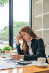 Business asian women are stress while working on laptop, Tired business woman with headache at...