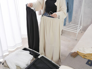 旅行の服を旅行鞄に詰める女性
