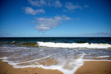 Beautiful beach with sand, tuquoise sea and blue sky with some clouds in synny summer day, selective focus
