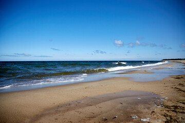 Beautiful beach with sand, tuquoise sea and blue sky with some clouds in synny summer day, selective focus