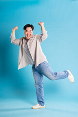 Full body image of Asian man posing on blue background