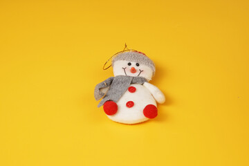 Snowman toy christmas decoration isolated on yellow background