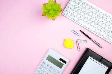 pink office table with computer, pen and a cup of coffee, lot of things. Top view with copy space.