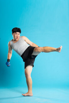 Image of Asian man exercising on blue background