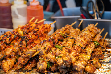 Grilling barbecue meat skewer kebab at traditional night market in South Korea.
