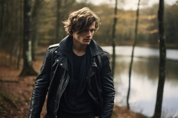 Cool Fictional Handsome Man Model Wearing Black Leather Jacket, Walking in a Forest. Generative AI. - Powered by Adobe