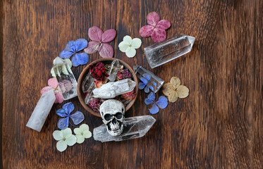 minerals, dry flowers and skull amulet on abstract wooden background. witch altar. Magic Crystal...