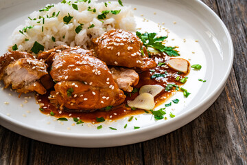 Hawaiian chicken style - shoyu chicken thighs with white rice on wooden table
