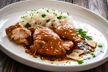 Hawaiian chicken style - shoyu chicken thighs with white rice on wooden table
