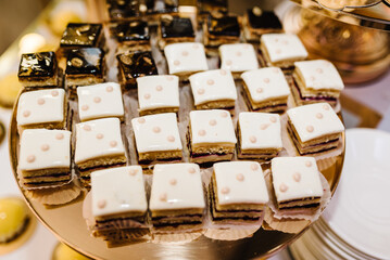 Candy bar with dessert for celebrating birthday, baptism. Decorated delicious. Sweet table. Plates of cakes and muffins. Table with sweets, buffet. Dessert table for party goodies for wedding. Closeup
