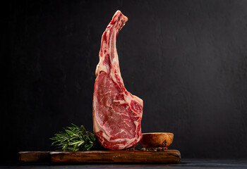 Raw Tomahawk beef steak and spices