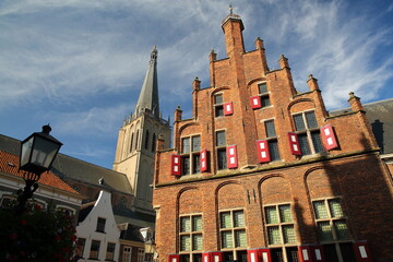 Traditional historic medieval houses in the old picturesque town of Doesburg, Gelderland, Netherlands, with the Stadhuis (Town Hall) and the bell tower of Martinikerk church 