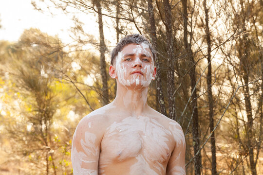 Pensive portrait of First Nations young man wearing ochre body paint