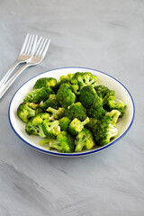 Homemade Pan-fried Broccoli on a Plate on a gray background, side view.