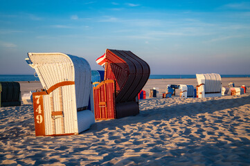 Colorful sunset panorama at main beach of Juist island in northern Germany. Traditional wickerwork...