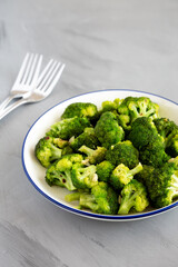 Homemade Pan-fried Broccoli on a Plate on a gray background, side view.