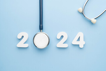 Stethoscope with 2024 number on blue background. Happy New Year for health care and medical banner...