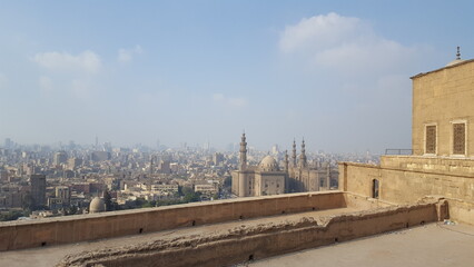 Fototapeta premium From the building's rooftop, watch as the bustling city unfolds, with gleaming skyscrapers and endless streams of people below.