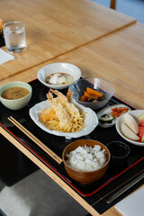 a Japanese set menu, consists of miso soup, soft boiled egg, vegetables, fruits and fried tempura