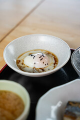 soft boiled egg with soy sauce and sesame seed on top