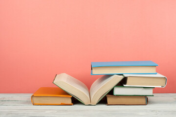Open book, hardback colorful books on wooden table. Back to school. Copy space for text. Education business concept.