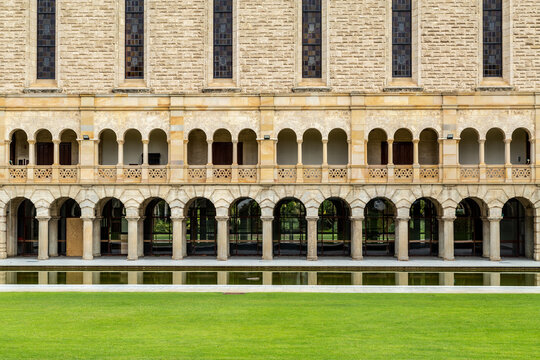 Old stone building with ornate arches and windows. - Powered by Adobe