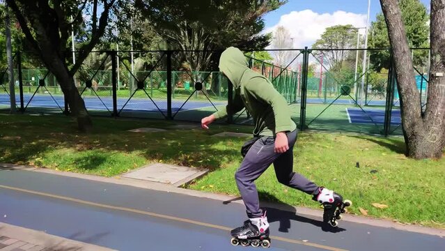 young man skating with roller skates in a city park