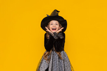 A funny and joyful child in a Halloween costume, on an isolated yellow background. A happy little...