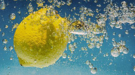 Underwater lemon slice in soda water or lemonade with bubbles. Refreshing soda tonic fizzy...