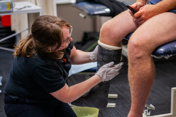 medical professional putting walking cast on leg