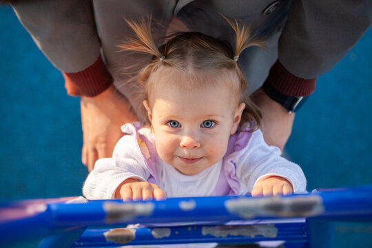 Young child climbing up blue ladder at park on playground