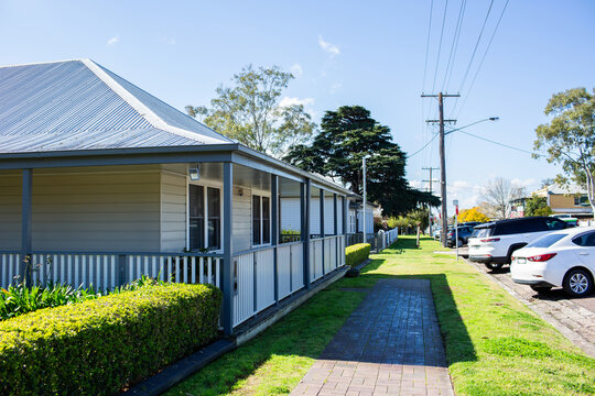 Weatherboard home with veranda alongside street in country suburb