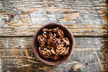 Bowl of organic walnuts on wooden table, autumn harvest time