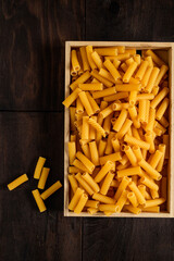 Macaroni or maccheroni, Italian raw pasta, in a wooden box.