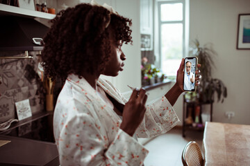 Young woman talking to her doctor over a video call on her smart phone