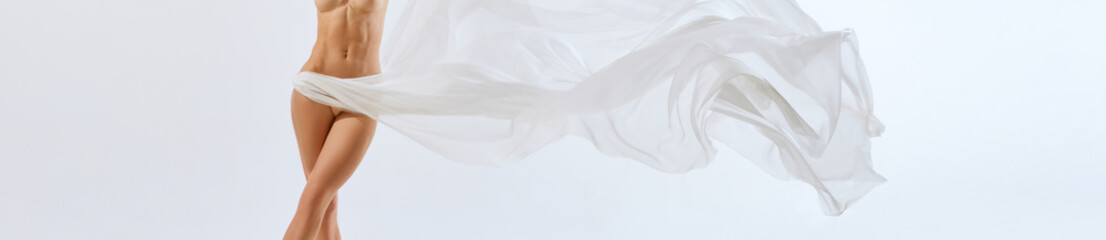 Banner. Cropped portrait. Fit body of young beautiful naked woman through transparent fabric on...