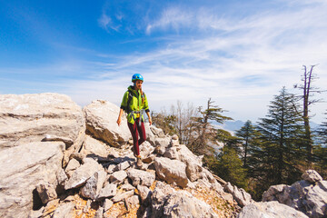 climber goes along the rocky ridge. girl climbing in the mountains. the concept of adventure and...